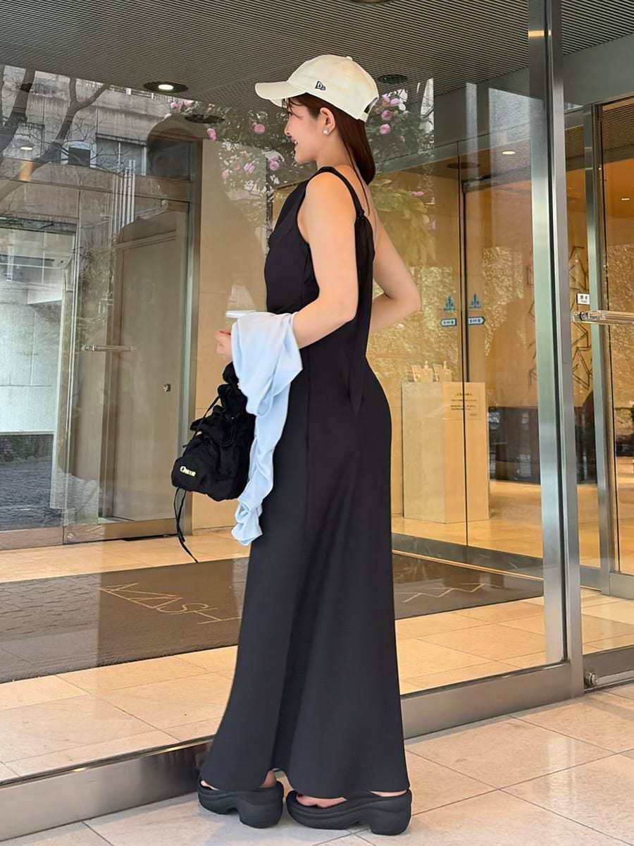 ブラック系のワンピース、ブルー系のカーディガン/ボレロ、ホワイト系のキャップを着用したレディースの春コーディネートの2枚目の写真