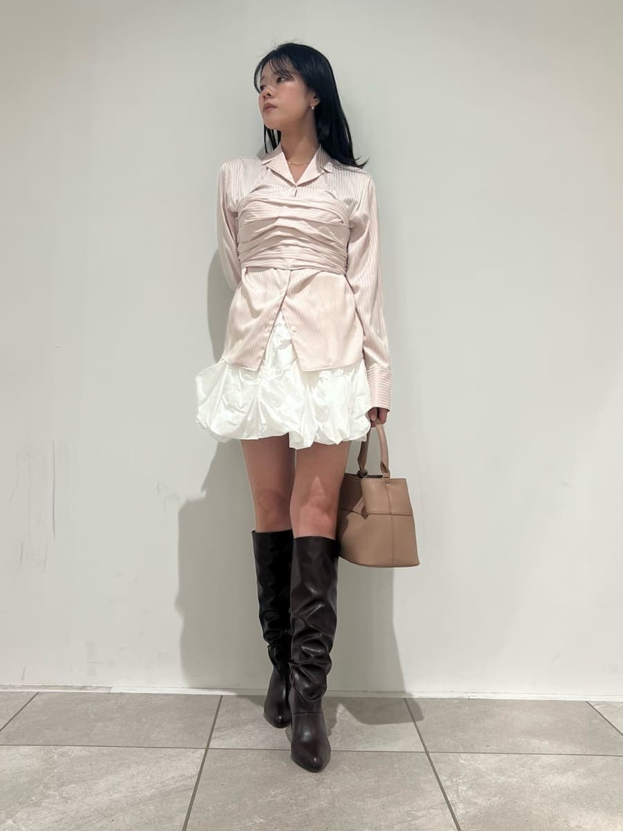 ピンク系のショルダーバッグ、ベージュ系のチェスターコート、ホワイト系のその他パンツを着用したレディースの冬コーディネートの5枚目の写真