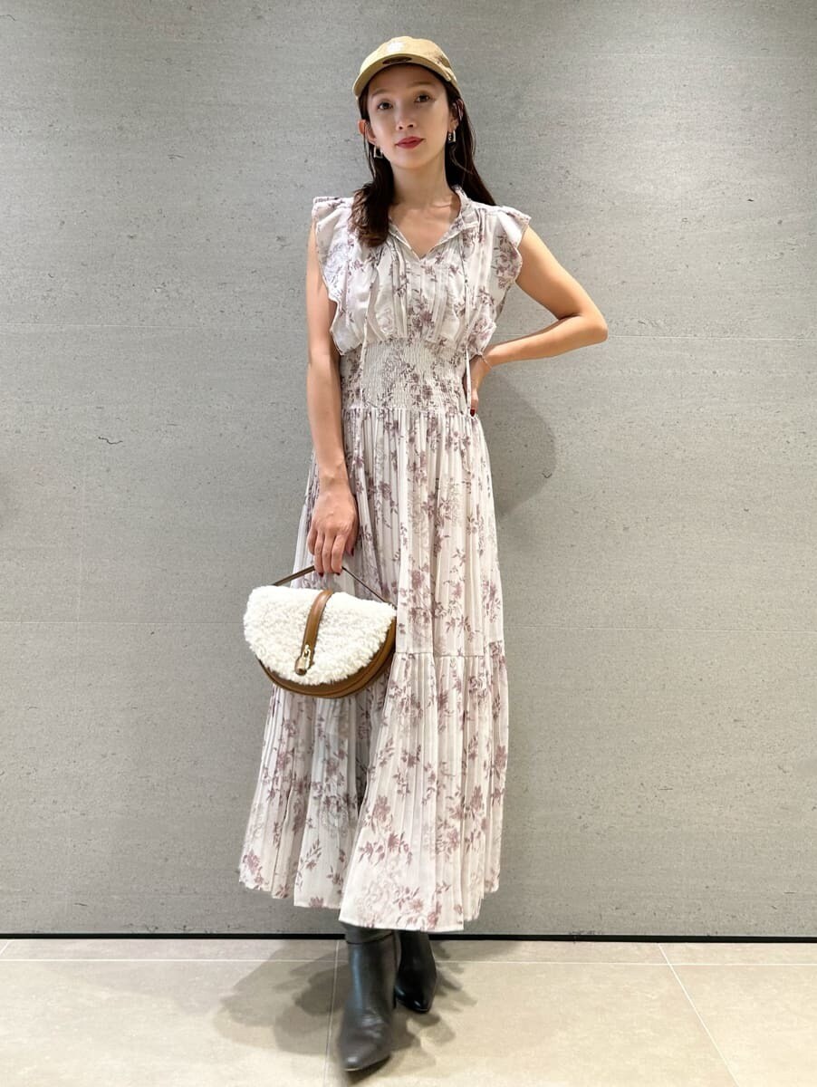 ピンク系のワンピース、イエロー系のハンドバッグ、グレー系のブーツを着用したレディースの秋コーディネートの3枚目の写真