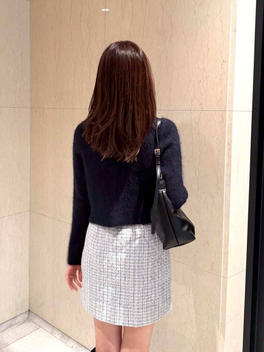 ブルー系のノーカラージャケット、ブルー系のスカート、ブラック系のブーツを着用したレディースの秋コーディネートの4枚目の写真