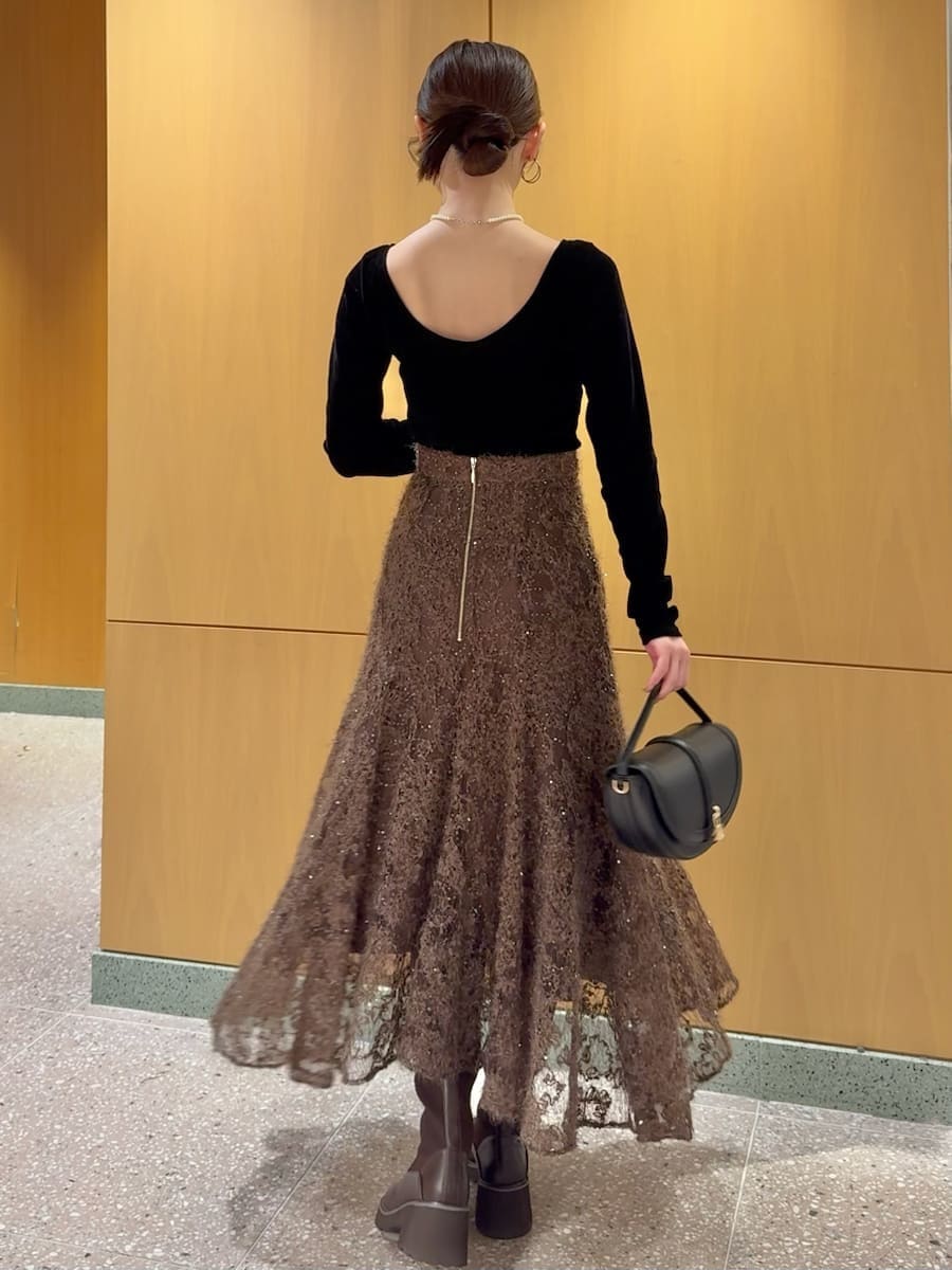 ブラック系のTシャツ/カットソー、ブラウン系のスカート、ブラック系のハンドバッグを着用したレディースの秋コーディネートの3枚目の写真