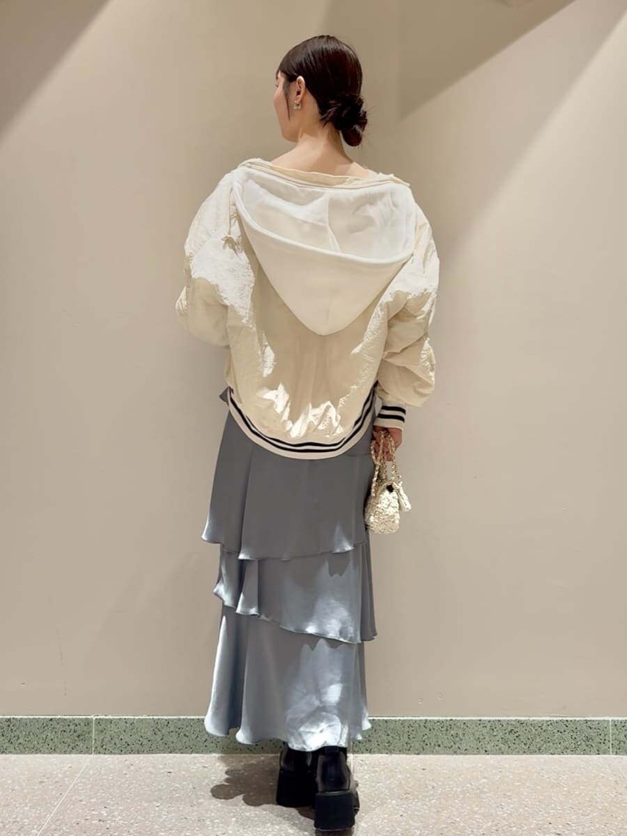 ホワイト系のブルゾン、ホワイト系のニット/セーター、ブルー系のスカートを着用したレディースの秋コーディネートの3枚目の写真