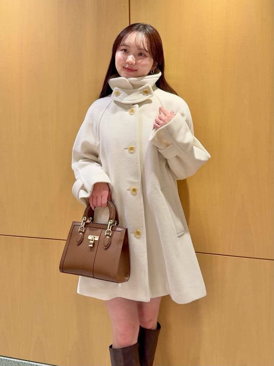 ホワイト系のステンカラーコート、その他のその他パンツ、ブラウン系のハンドバッグを着用したレディースの冬コーディネートの7枚目の写真