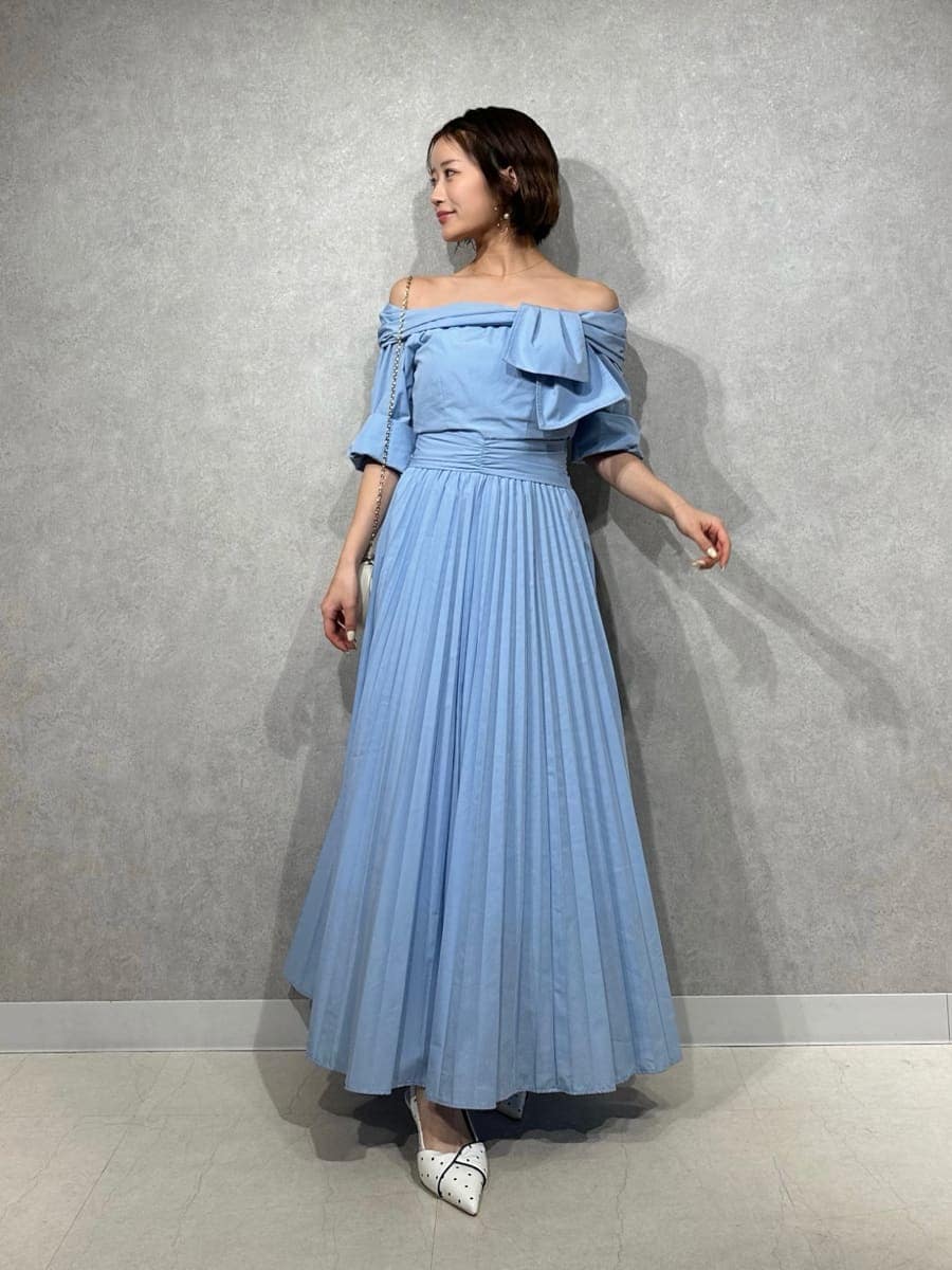 ブルー系のワンピース、その他のパンプス、ホワイト系のショルダーバッグを着用したレディースの冬コーディネートの2枚目の写真