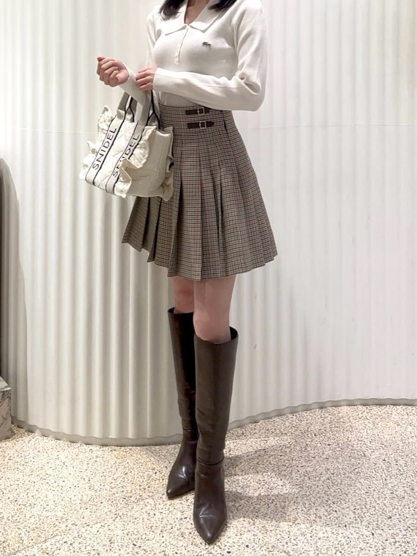 ベージュ系のスカート、ブラウン系のブーツ、ホワイト系のダウンジャケット/コートを着用したレディースの秋コーディネートの5枚目の写真