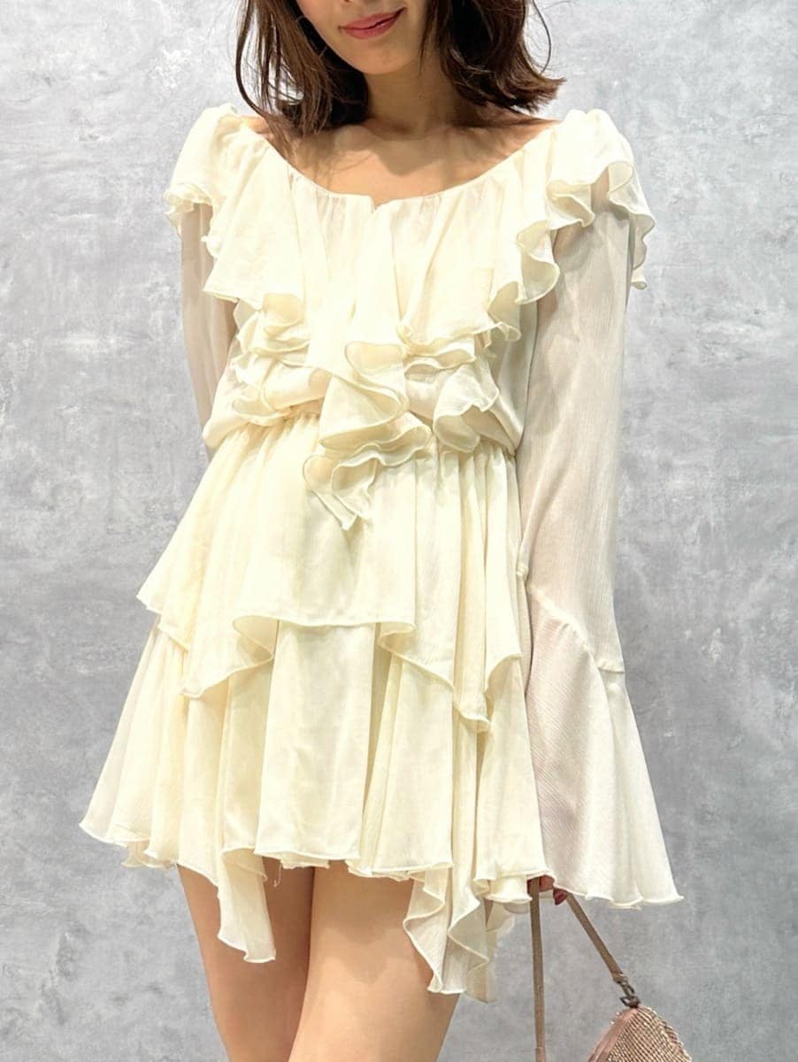 グレー系のステンカラーコート、ホワイト系のワンピースを着用したレディースの秋コーディネートの6枚目の写真