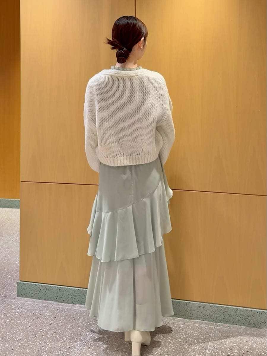 グリーン系のワンピース、ホワイト系のカーディガン/ボレロを着用したレディースの冬コーディネートの3枚目の写真