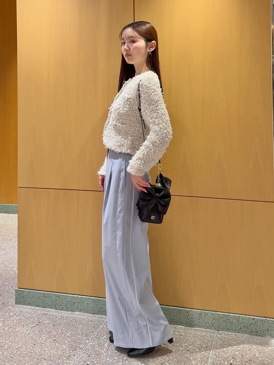 ブルー系のその他パンツ、ホワイト系のカーディガン/ボレロ、ブラック系のブーツを着用したレディースの冬コーディネートの2枚目の写真