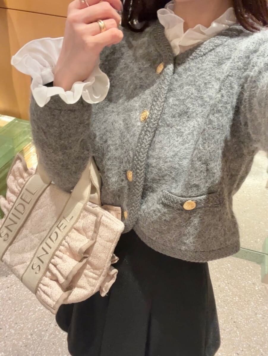 グレー系のノーカラージャケット、ブラック系のスカート、ピンク系のハンドバッグを着用したレディースの秋コーディネートの8枚目の写真