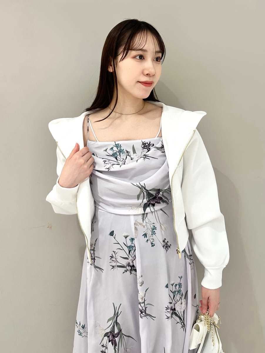 ホワイト系のパーカー、パープル系のワンピース、ブラウン系のパンプスを着用したレディースの冬コーディネートの2枚目の写真