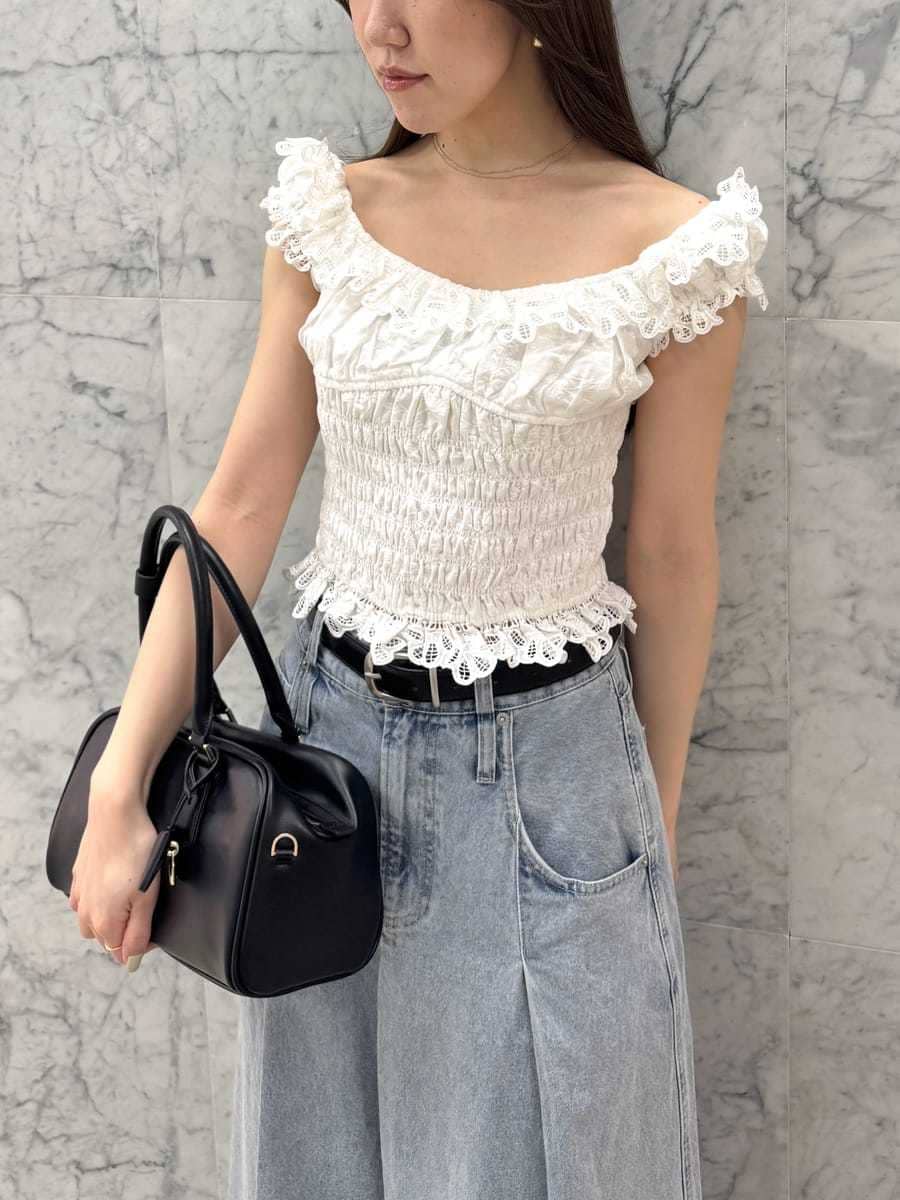 ブルー系のスカート、ホワイト系のシャツ/ブラウス、ブラック系のボストンバッグを着用したレディースの春コーディネートの4枚目の写真