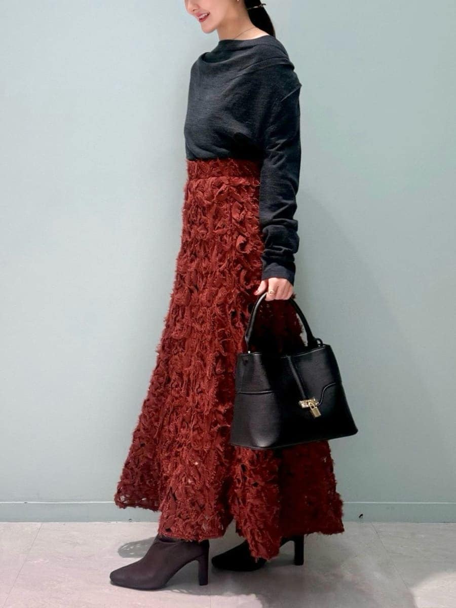 レッド系のブーツ、グレー系のチェスターコート、レッド系のスカートを着用したレディースの冬コーディネートの8枚目の写真