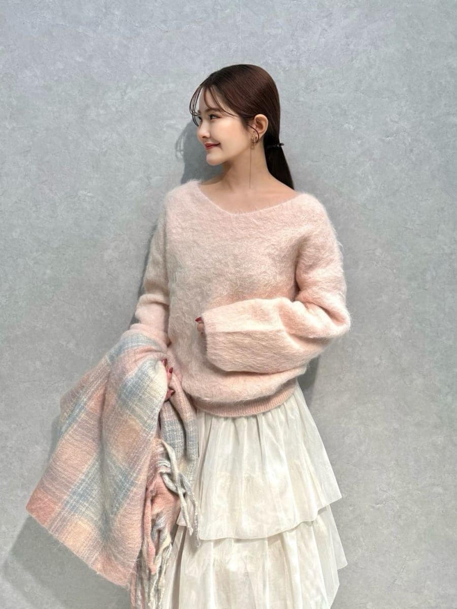 ピンク系のニット/セーター、ホワイト系のチェスターコート、ホワイト系のスカートを着用したレディースの冬コーディネートの9枚目の写真