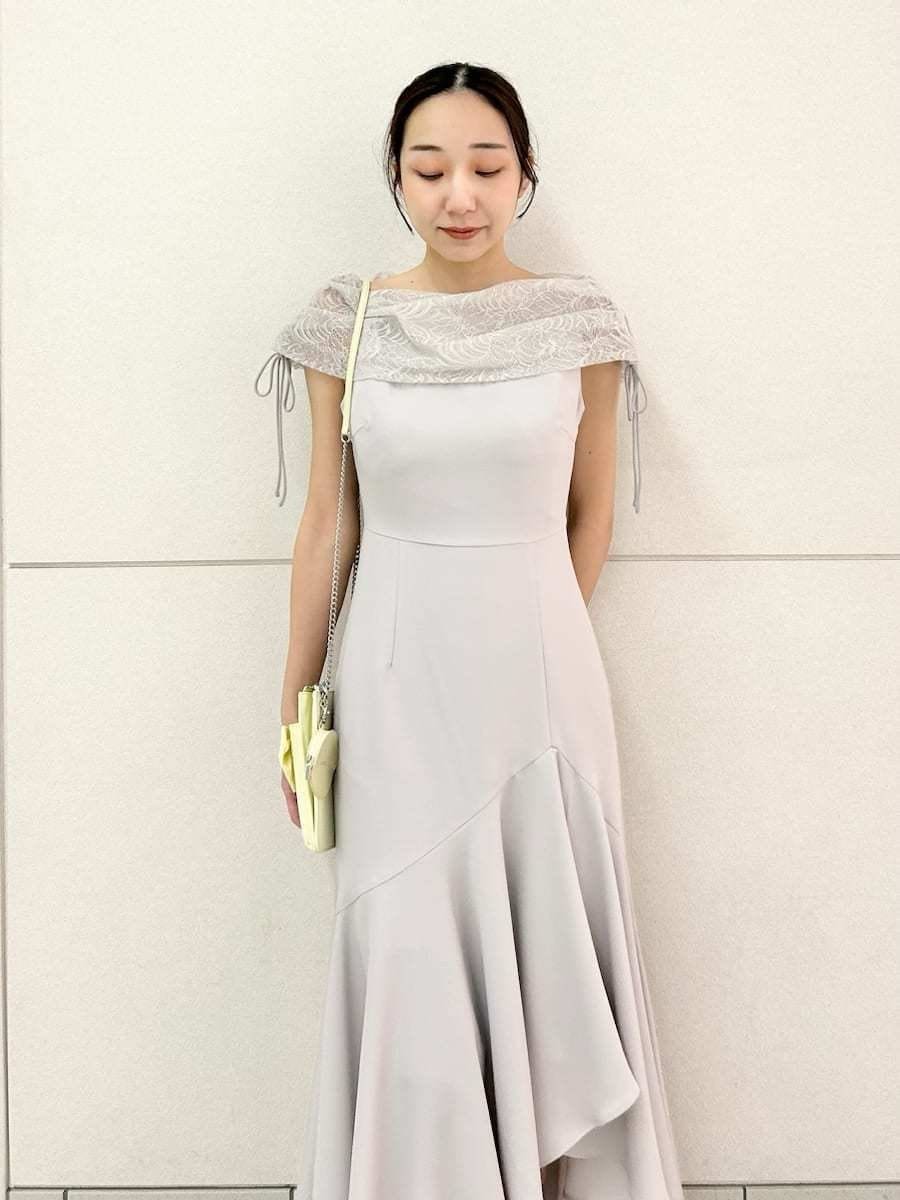 グレー系のドレス、ブラウン系のパンプス、イエロー系のショルダーバッグを着用したレディースの春コーディネートの4枚目の写真