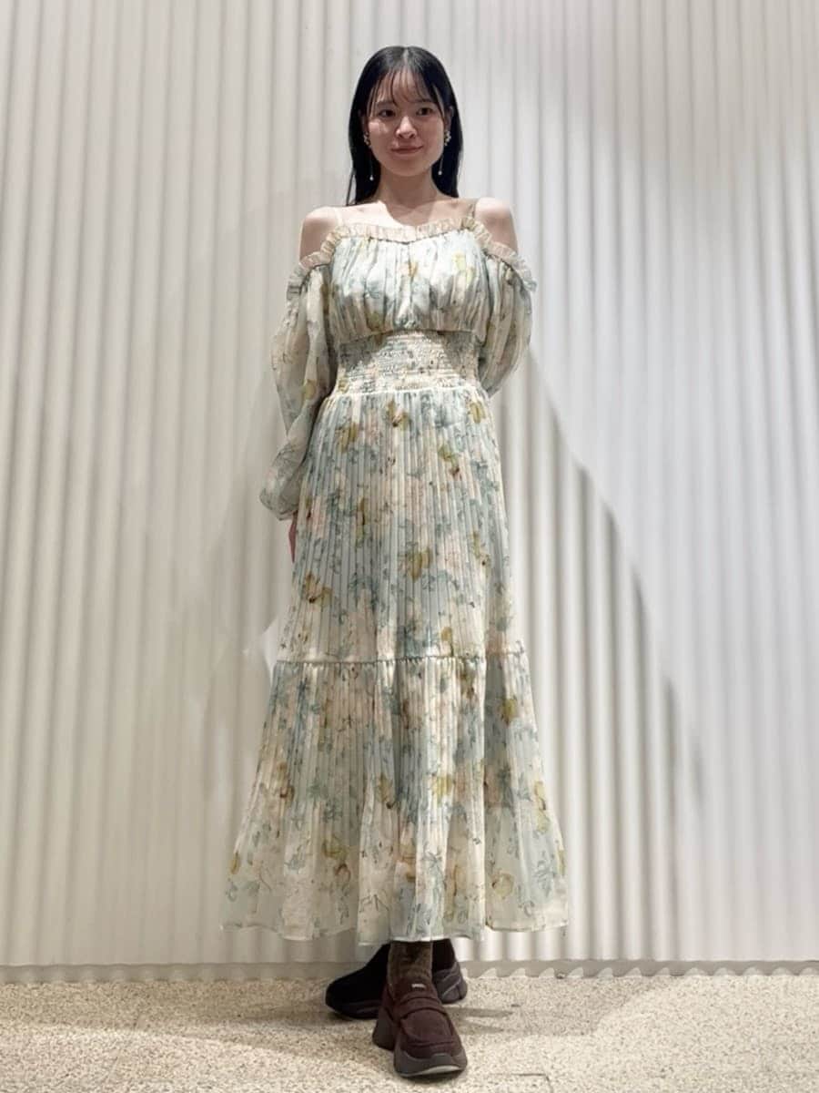 グリーン系のワンピース、ホワイト系のショルダーバッグ、ブラウン系のローファーを着用したレディースの冬コーディネートの3枚目の写真