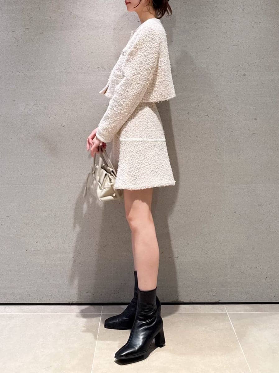 その他のノーカラージャケット、その他のスカート、ホワイト系のボストンバッグを着用したレディースの冬コーディネートの2枚目の写真