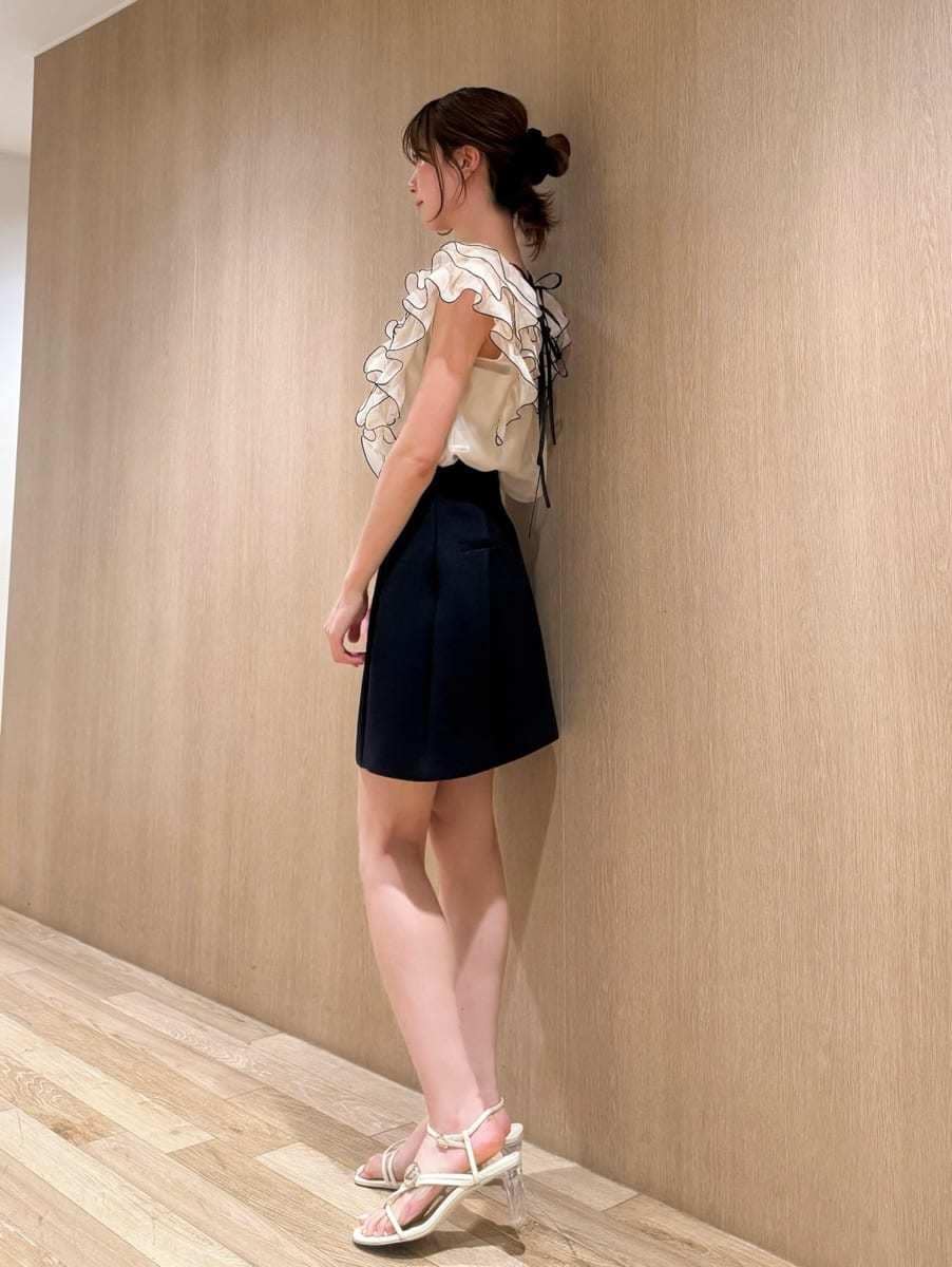 ブルー系のスカート、ベージュ系のシャツ/ブラウスを着用したレディースの春コーディネートの2枚目の写真