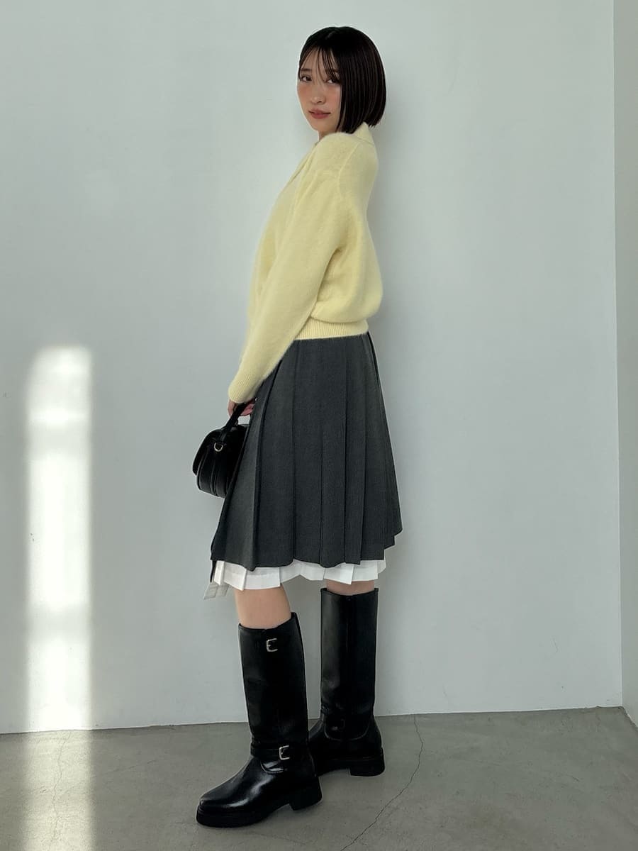 ブラック系のブーツ、ブラック系のハンドバッグ、イエロー系のニット/セーターを着用したレディースの秋コーディネートの6枚目の写真