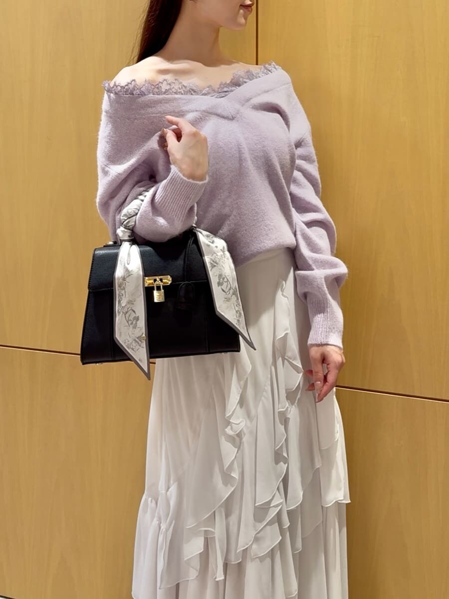 パープル系のニット/セーター、ホワイト系のスカート、ブラック系のブーツを着用したレディースの秋コーディネートの6枚目の写真