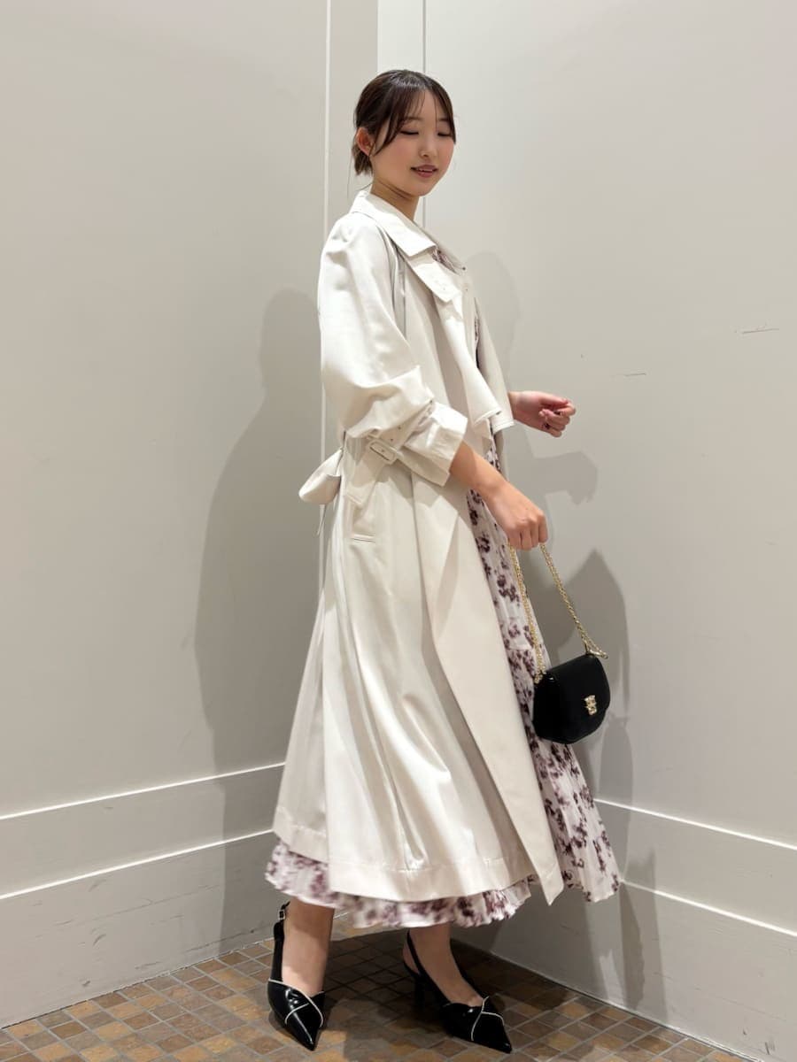 ホワイト系のトレンチコート、ピンク系のワンピース、ブラック系のパンプスを着用したレディースの冬コーディネートの2枚目の写真