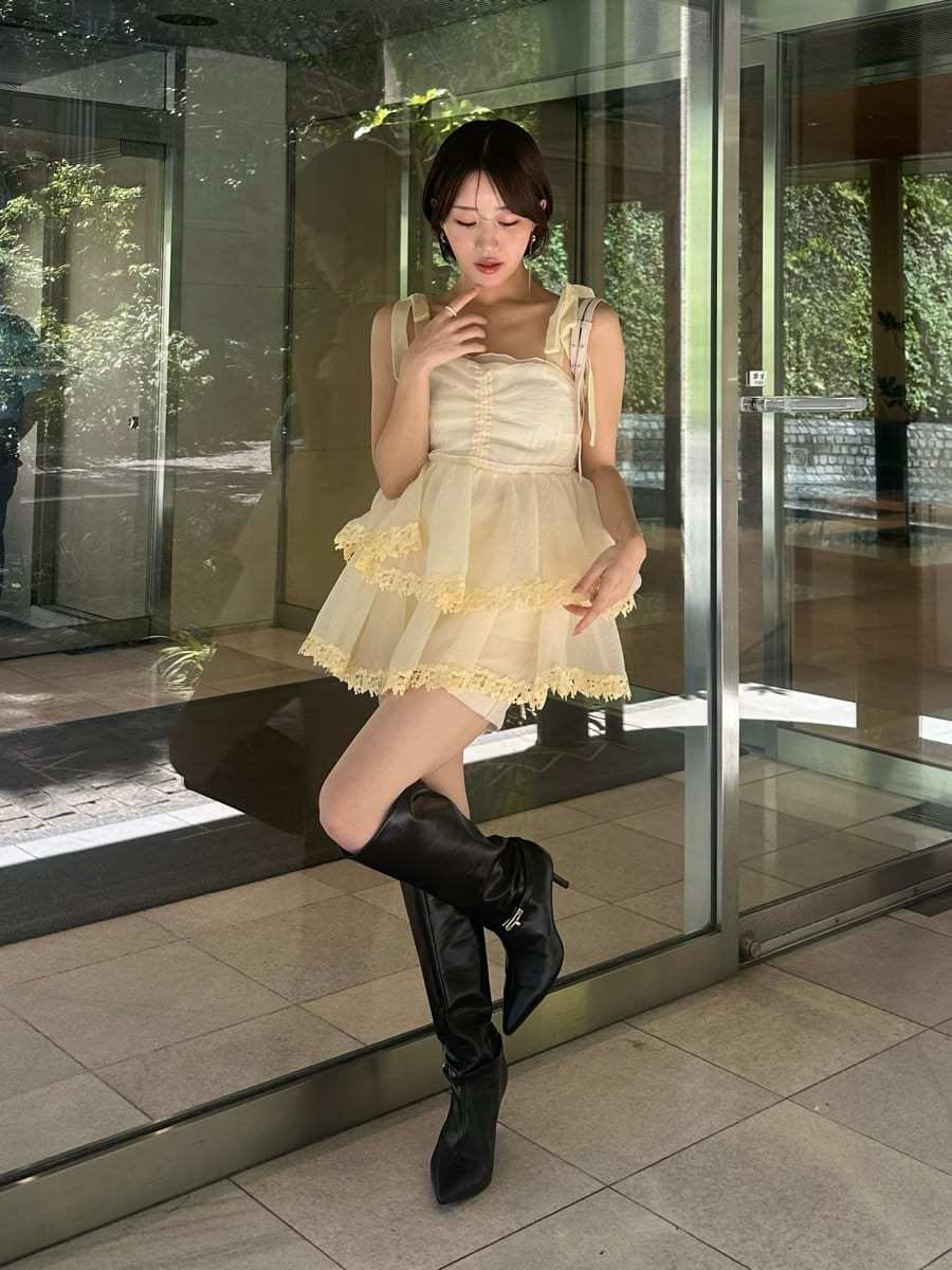 イエロー系のその他トップス、ブラック系のブーツ、ホワイト系のバックパック/リュックを着用したレディースの夏コーディネートの2枚目の写真