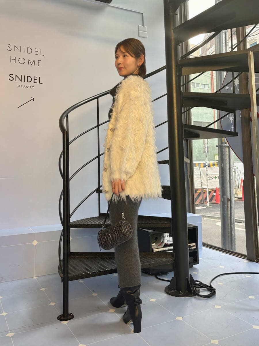 グレー系のワンピース、ホワイト系のカーディガン/ボレロを着用したレディースの冬コーディネートの2枚目の写真