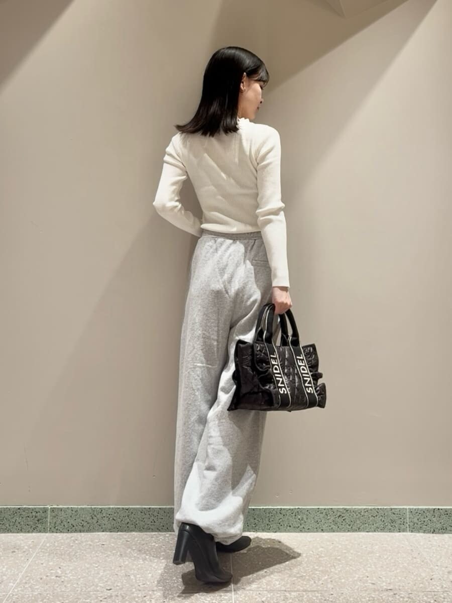 ホワイト系のニット/セーター、グレー系のその他パンツ、ブラック系のブーツを着用したレディースの秋コーディネートの3枚目の写真