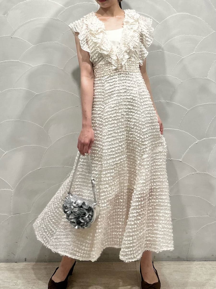 ホワイト系のドレス、シルバー系のハンドバッグを着用したレディースの春コーディネートの2枚目の写真