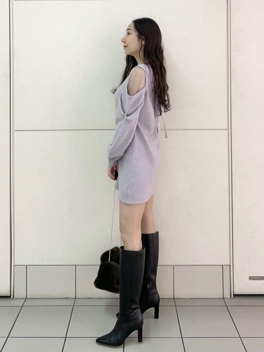 ブラック系のブーツ、パープル系のワンピース、ブラウン系のハンドバッグを着用したレディースの冬コーディネートの3枚目の写真