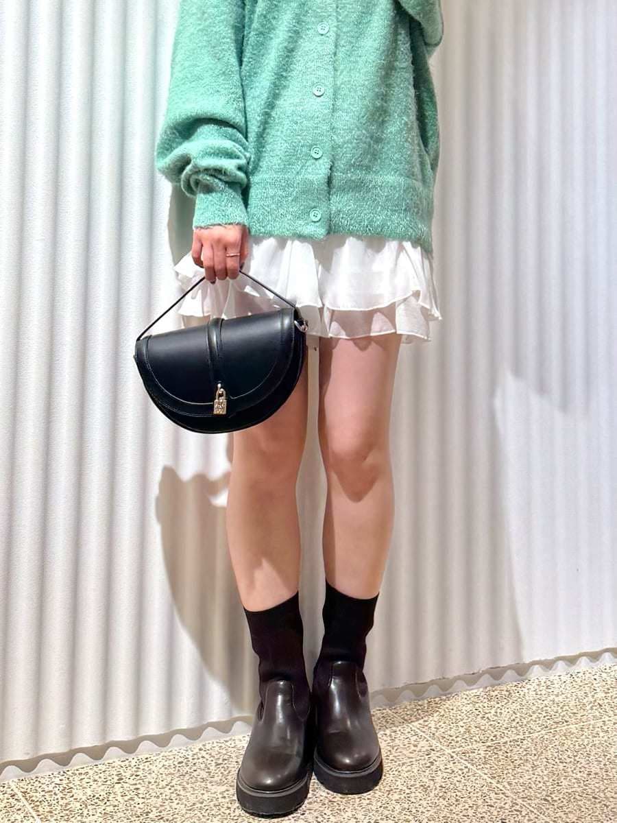 グリーン系のカーディガン/ボレロ、ホワイト系のその他パンツ、ブラック系のハンドバッグを着用したレディースの秋コーディネートの7枚目の写真