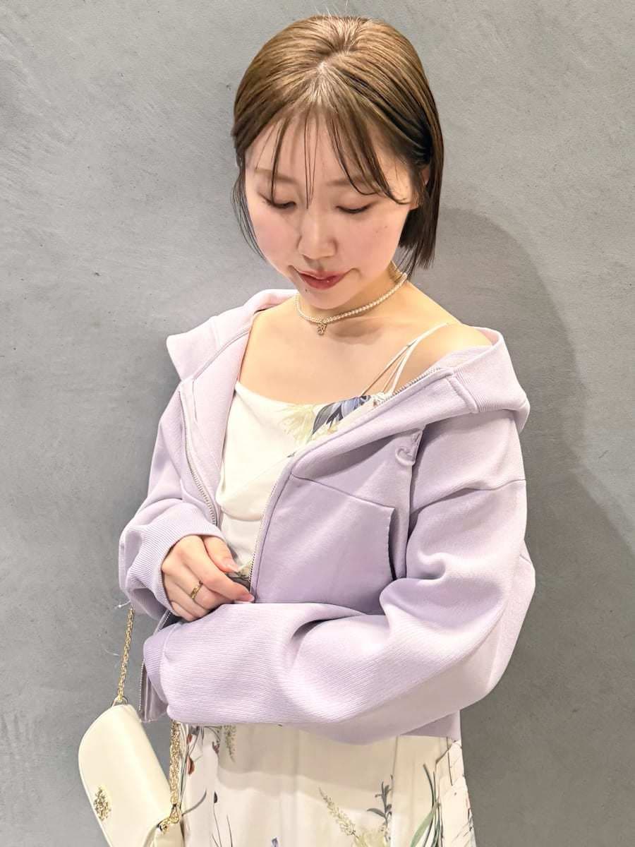 パープル系のパーカー、ホワイト系のワンピース、ブラウン系のパンプスを着用したレディースの冬コーディネートの10枚目の写真