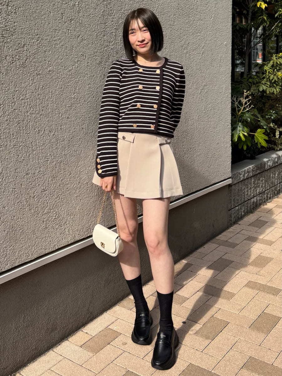 ベージュ系のスカート、その他のカーディガン/ボレロ、ホワイト系のショルダーバッグを着用したレディースの冬コーディネートの2枚目の写真