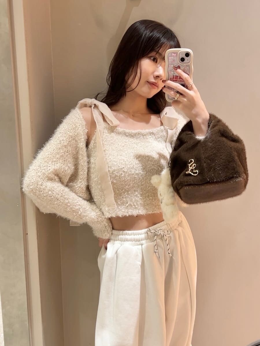 レッド系のブーツ、ホワイト系のニット/セーター、ホワイト系のスウェットパンツを着用したレディースの冬コーディネートの7枚目の写真