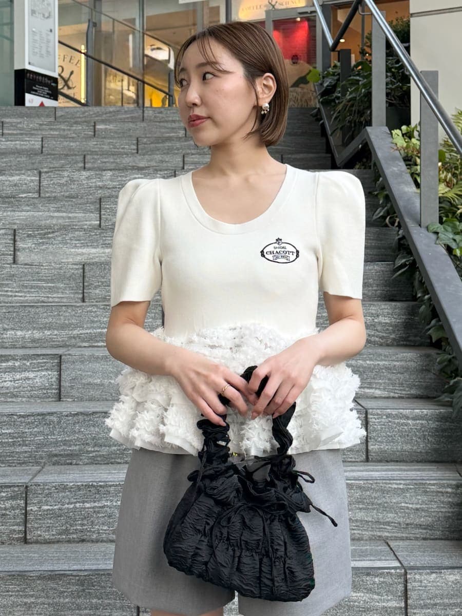 ホワイト系のニット/セーター、グレー系のその他パンツを着用したレディースの春コーディネートの3枚目の写真