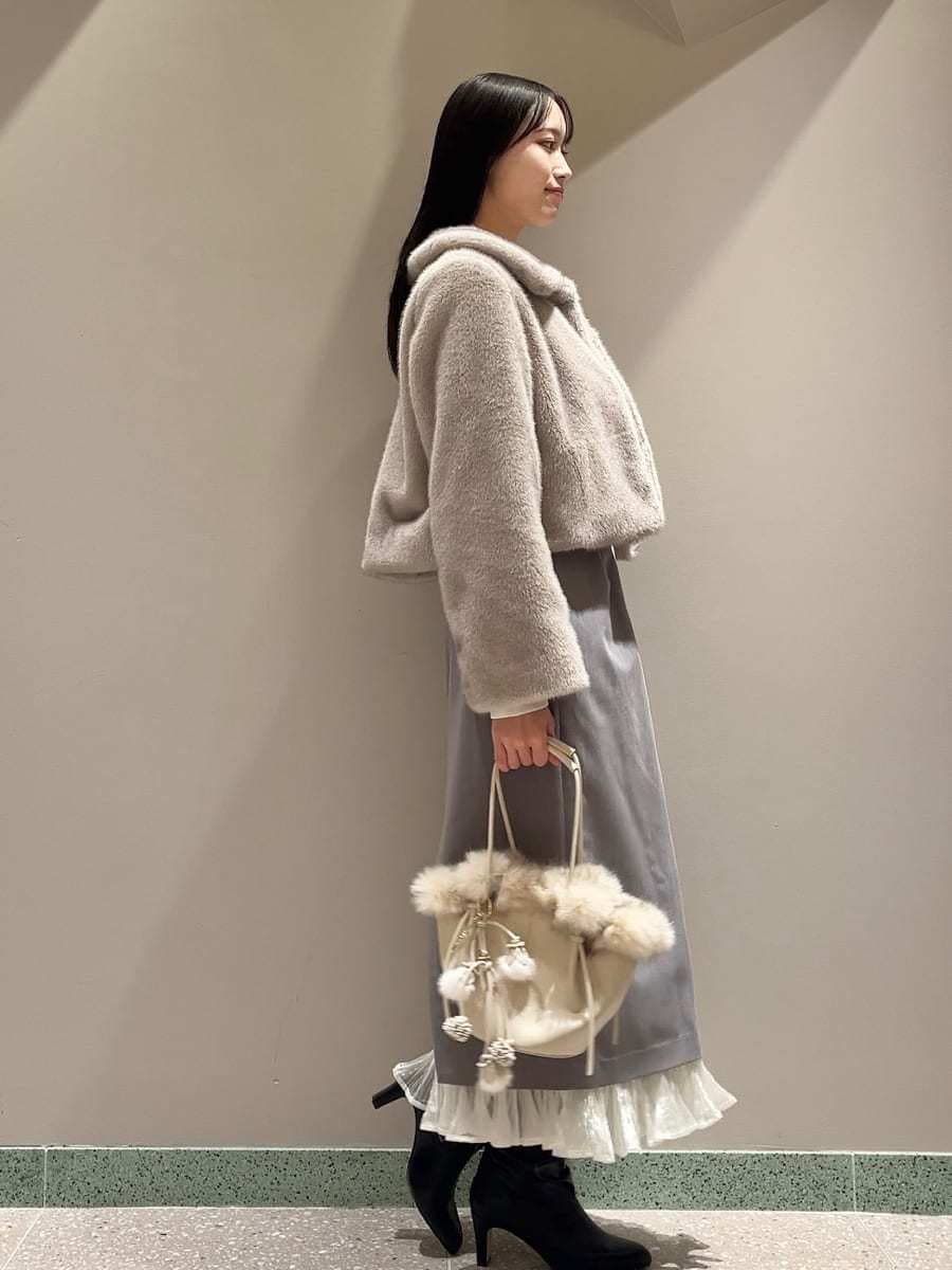 ベージュ系のステンカラーコート、その他のスカート、ホワイト系のハンドバッグを着用したレディースの秋コーディネートの2枚目の写真