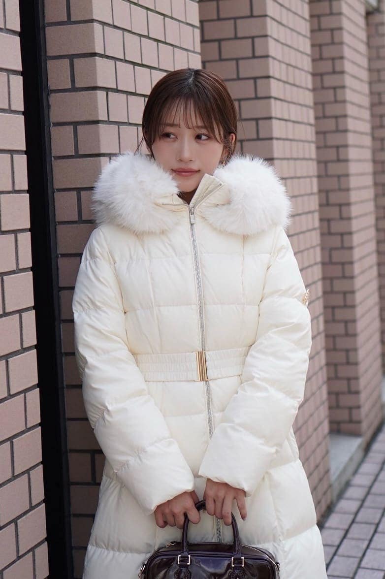 ブラック系のブーツ、ブラック系のボストンバッグ、ホワイト系のダウンジャケット/コートを着用したレディースの秋コーディネートの4枚目の写真