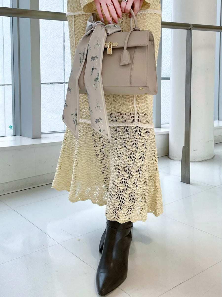 グレー系のブーツ、イエロー系のスカート、イエロー系のニット/セーターを着用したレディースの春コーディネートの5枚目の写真