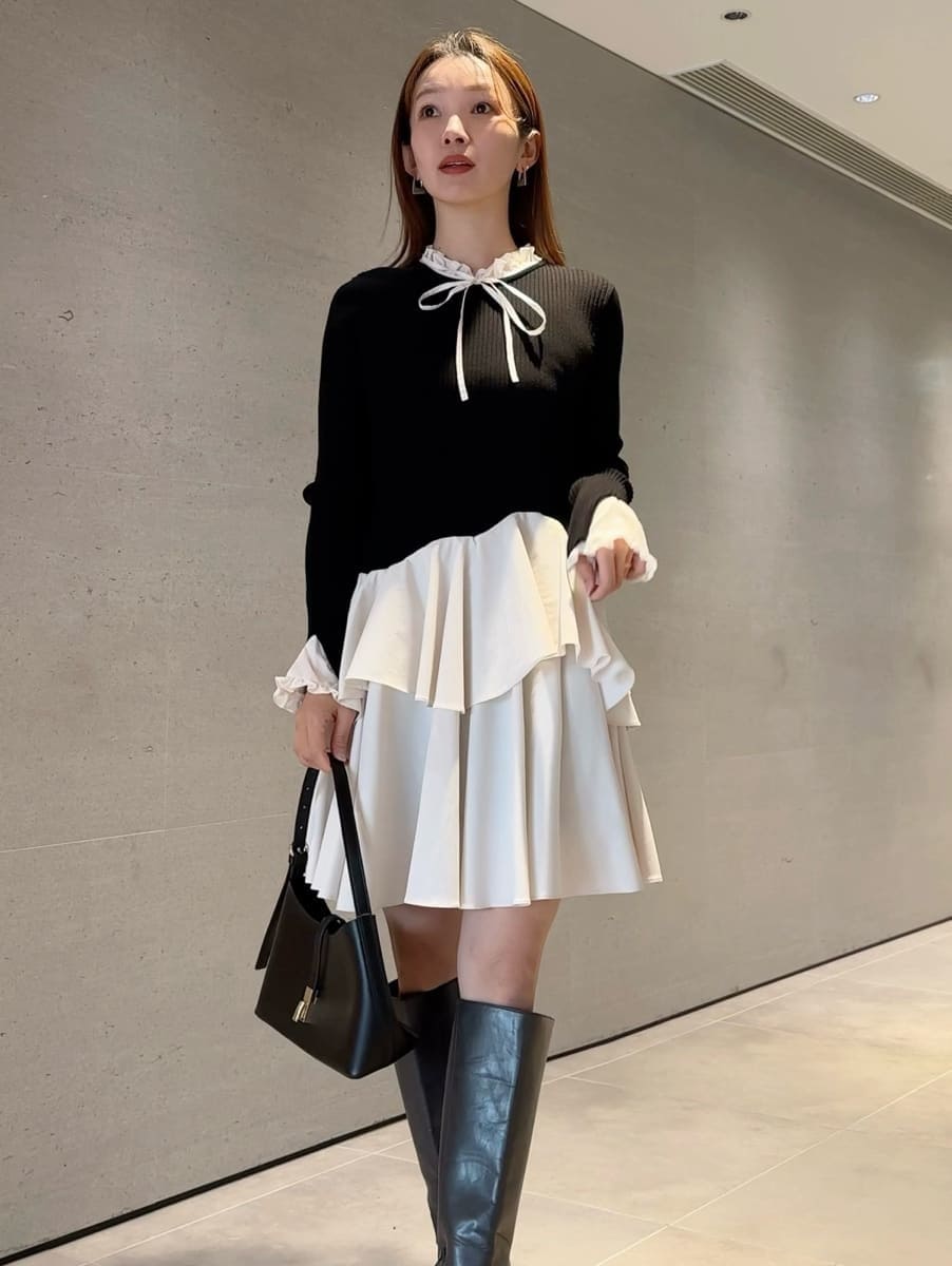 ブラック系のショルダーバッグ、グレー系のブーツ、ブラック系のワンピースを着用したレディースの冬コーディネートの3枚目の写真