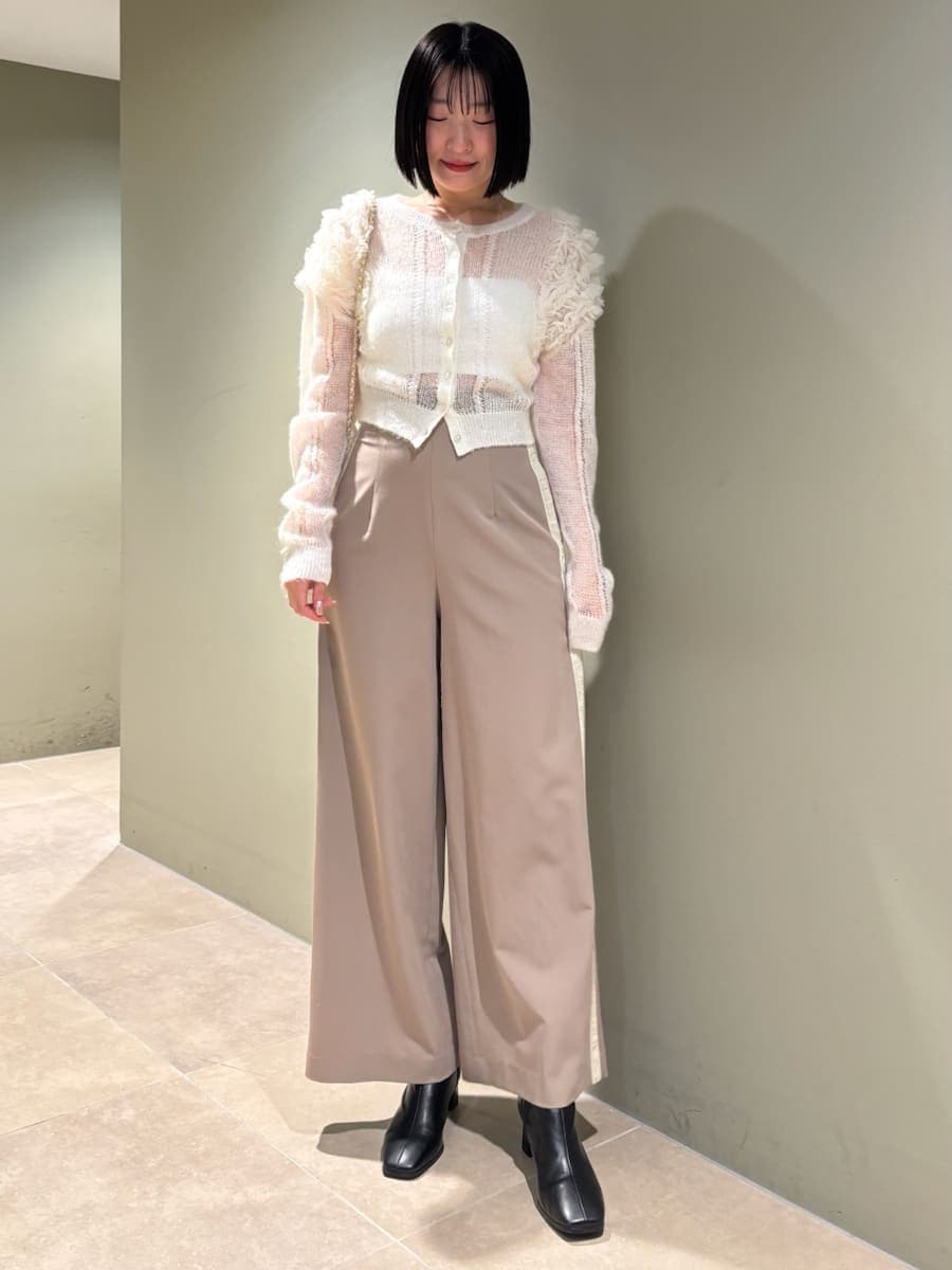 ホワイト系のカーディガン/ボレロ、ホワイト系のショルダーバッグ、ブラウン系のその他パンツを着用したレディースの冬コーディネートの2枚目の写真