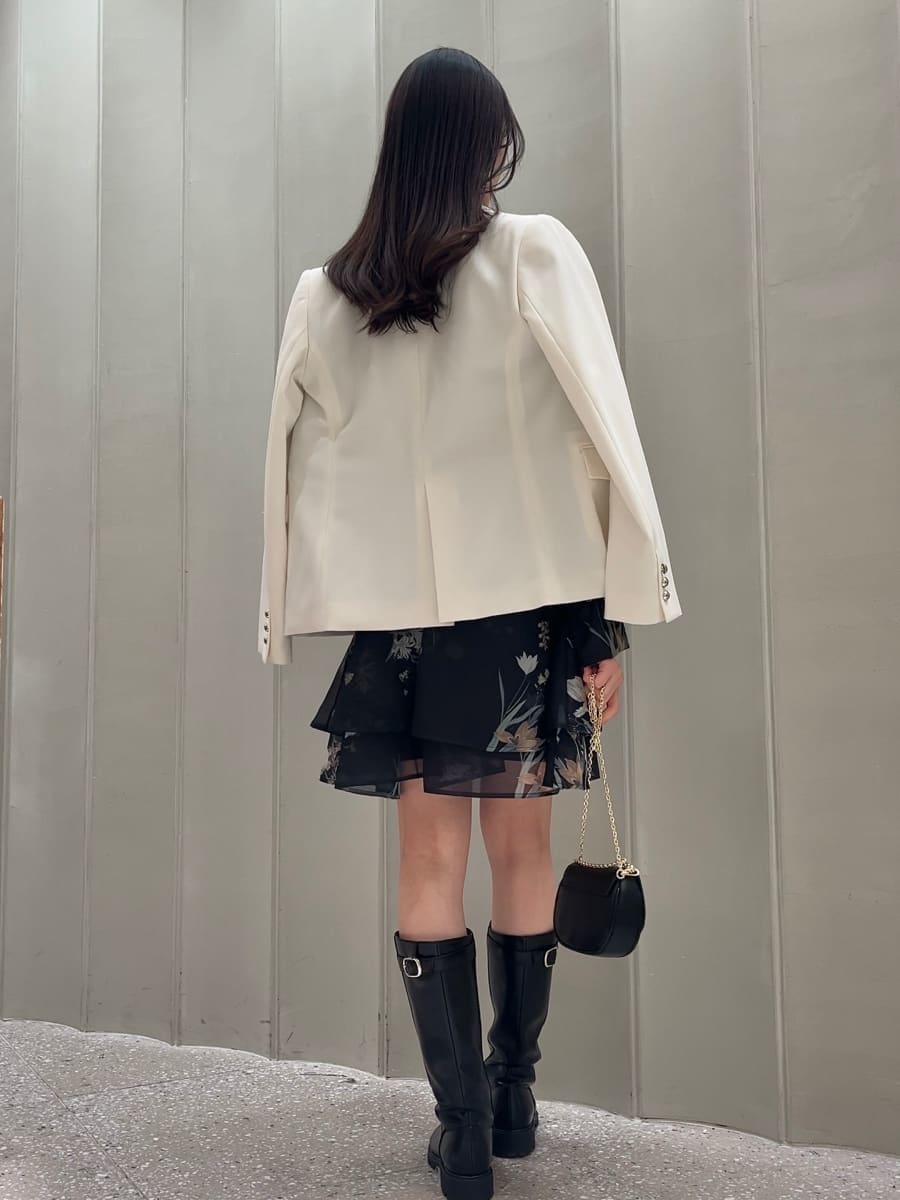 ホワイト系のテーラードジャケット、ブルー系のワンピース、ブラック系のショルダーバッグを着用したレディースの冬コーディネートの4枚目の写真