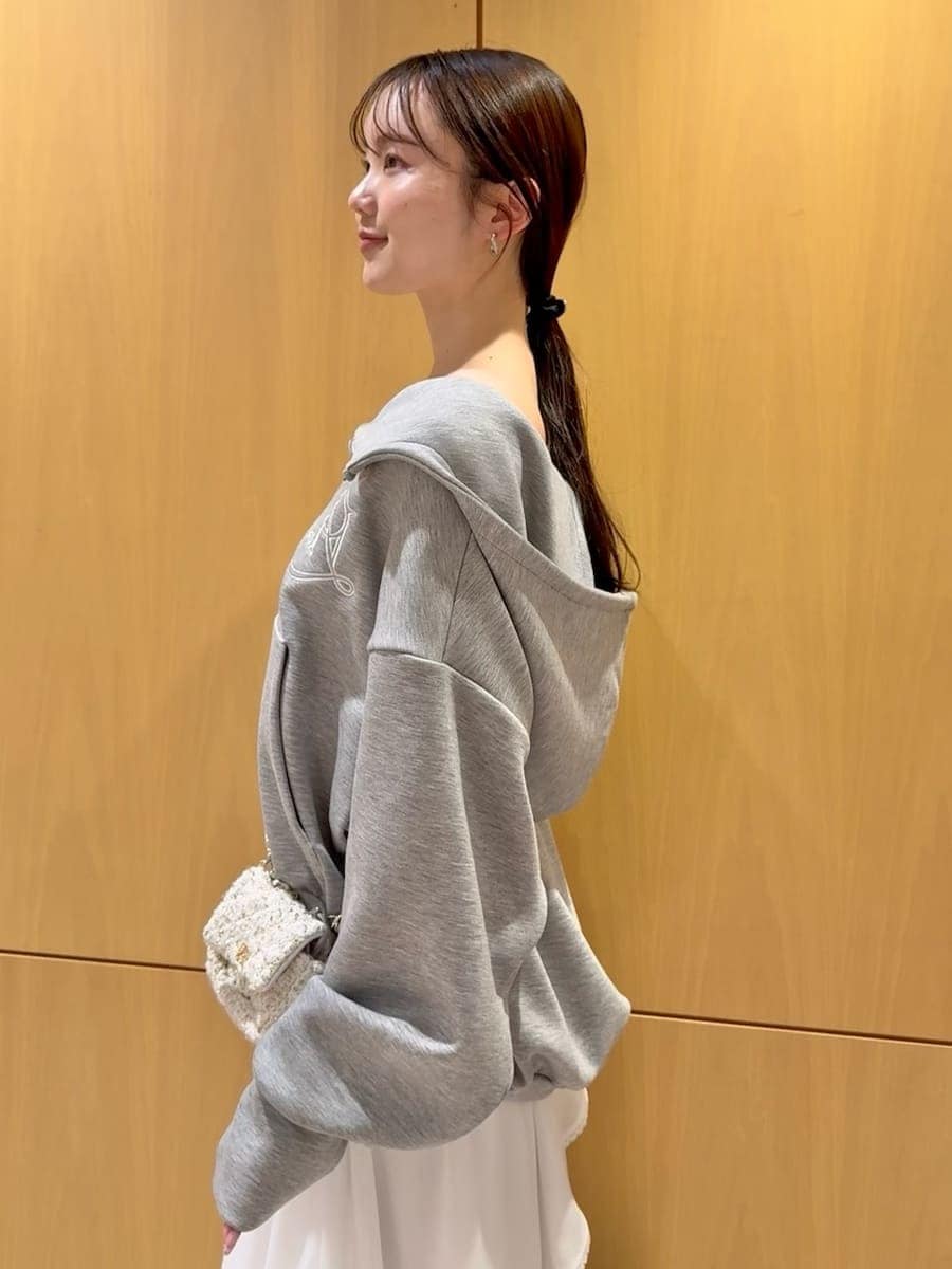 ホワイト系のショルダーバッグ、ホワイト系のスカート、グレー系のパーカーを着用したレディースの冬コーディネートの5枚目の写真