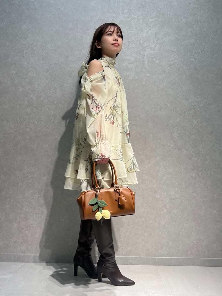 ブラウン系のブーツ、イエロー系のワンピース、イエロー系のボストンバッグを着用したレディースの冬コーディネートの3枚目の写真