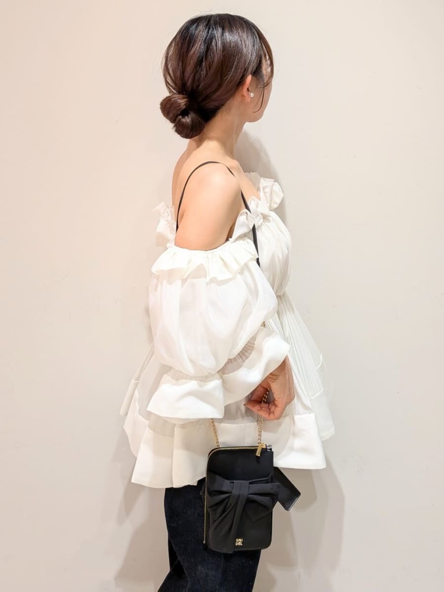 ブルー系のデニムパンツ、ホワイト系のその他トップス、ブラック系のショルダーバッグを着用したレディースの春コーディネートの4枚目の写真