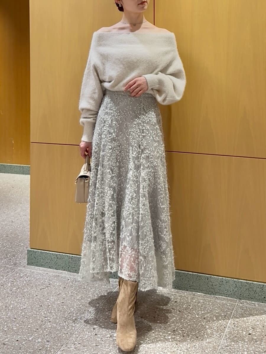 ホワイト系のニット/セーター、グリーン系のスカート、ベージュ系のブーツを着用したレディースの秋コーディネートの6枚目の写真