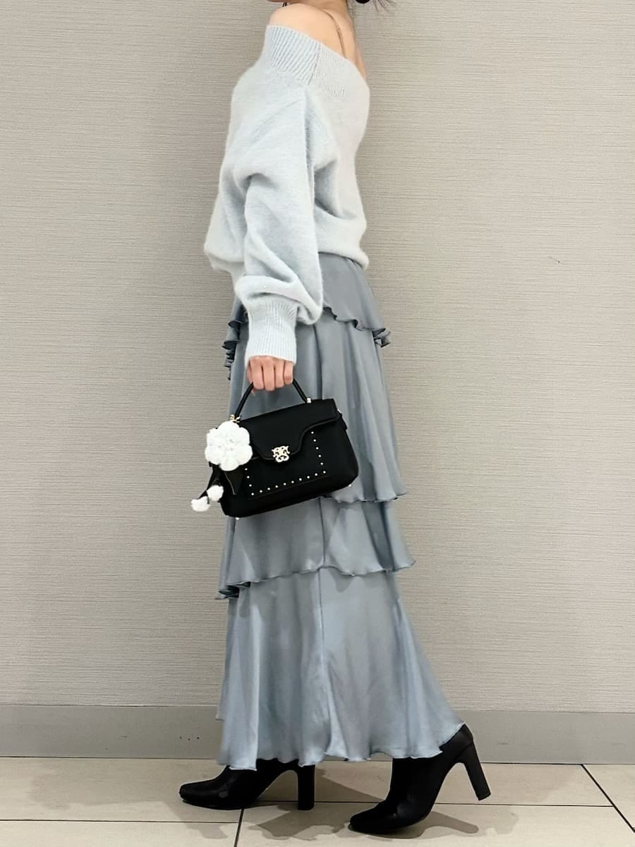 ブルー系のニット/セーター、ブルー系のスカート、ブラック系のブーツを着用したレディースの秋コーディネートの2枚目の写真