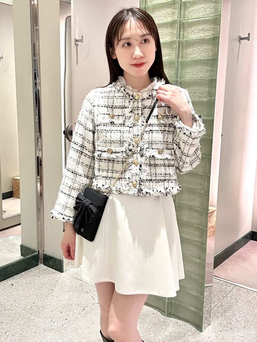 ホワイト系のノーカラージャケット、ホワイト系のその他パンツ、ブラック系のショルダーバッグを着用したレディースの冬コーディネートの2枚目の写真