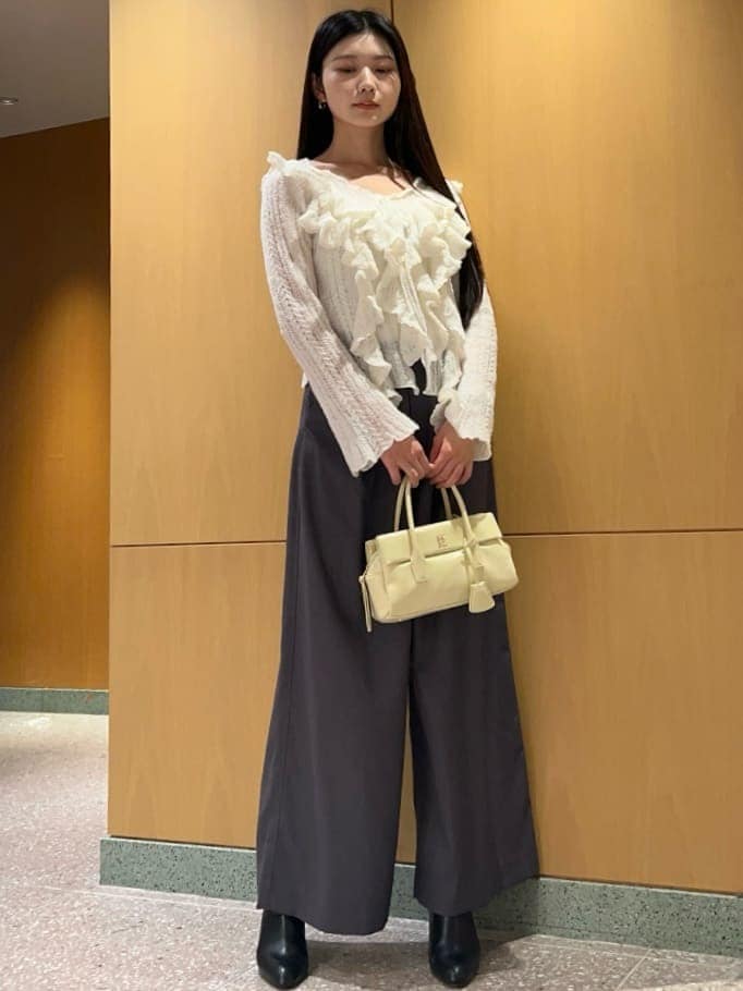 ホワイト系のニット/セーター、イエロー系のボストンバッグを着用したレディースの冬コーディネートの2枚目の写真