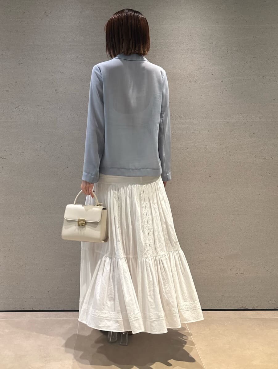 ブルー系のテーラードジャケット、ホワイト系のスカート、ホワイト系のショルダーバッグを着用したレディースの夏コーディネートの4枚目の写真
