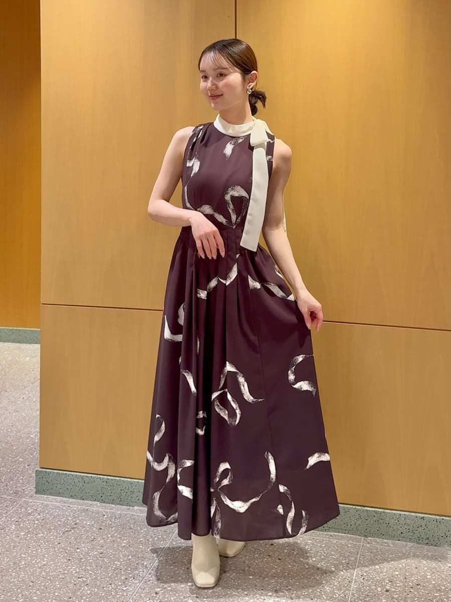 ホワイト系のショルダーバッグ、ブラウン系のワンピース、シルバー系のピアス（両耳用）を着用したレディースの冬コーディネートの4枚目の写真