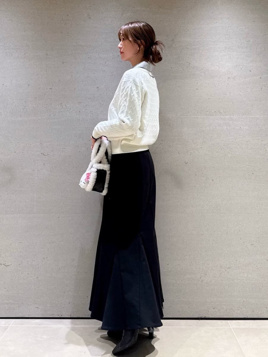 ホワイト系のニット/セーター、ブラック系のハンドバッグ、ブルー系のシャツ/ブラウスを着用したレディースの秋コーディネートの2枚目の写真